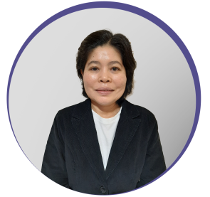 Imagem circular de uma mulher de traços orientais e fios pretos liso e curtos pousando para foto. Ela usa casaco preto de botões e camisa branca. É a doutora Taís Fukuta da Cruz.